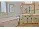 Bright bathroom with a modern soaking tub, double vanity, and wood-look tile flooring at 175 Thomas Overby Dr, Sharpsburg, GA 30277