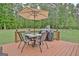 Enjoy outdoor dining on the deck with an umbrella-covered table and grill overlooking the manicured backyard at 175 Thomas Overby Dr, Sharpsburg, GA 30277