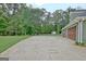 Spacious driveway leading to the garage, with a view of the home's exterior and the surrounding greenery at 175 Thomas Overby Dr, Sharpsburg, GA 30277