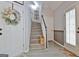 A welcoming entryway with a staircase and a decorative floral wreath on the front door at 175 Thomas Overby Dr, Sharpsburg, GA 30277
