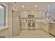 Modern kitchen with stainless appliances, custom cabinets, and a view into the adjacent dining area at 175 Thomas Overby Dr, Sharpsburg, GA 30277
