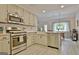 Modern kitchen with stainless appliances opens into the dining area with stylish lighting and decor at 175 Thomas Overby Dr, Sharpsburg, GA 30277
