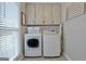 Bright laundry room with white cabinets, washer and dryer at 175 Thomas Overby Dr, Sharpsburg, GA 30277