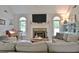 This living room is enhanced by bright windows and a cozy fireplace at 175 Thomas Overby Dr, Sharpsburg, GA 30277
