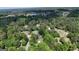 Expansive aerial view of a residential neighborhood, densely wooded with a lake and golf course nearby at 3456 Village Glen Ct, Snellville, GA 30039