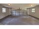 Empty garage featuring a gray concrete floor, a closed garage door, and two windows at 3456 Village Glen Ct, Snellville, GA 30039