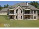 Expansive backyard of a brick home with covered balconies and lush green lawn at 315 Westbourne Dr, Tyrone, GA 30290
