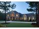 Beautiful stone home featuring manicured landscaping and inviting entryway during twilight hours at 315 Westbourne Dr, Tyrone, GA 30290