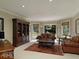 The living room has a leather sofa and chairs, a bookcase and a view of the yard at 315 Westbourne Dr, Tyrone, GA 30290