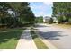 Quiet street view showing a house with manicured lawns and mature trees at 315 Westbourne Dr, Tyrone, GA 30290