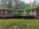 View of the backyard featuring a raised wooden deck and mature shade trees at 205 Aberdeen Dr, Peachtree City, GA 30269