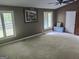 A large bedroom with neutral carpeting, large windows, and light-brown walls at 205 Aberdeen Dr, Peachtree City, GA 30269