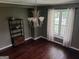 A formal dining room with a large window, hardwood flooring, and an elegant chandelier at 205 Aberdeen Dr, Peachtree City, GA 30269