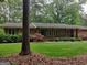 Ranch style home featuring a combination of stone and painted siding, set on a wooded lot with mature trees at 205 Aberdeen Dr, Peachtree City, GA 30269