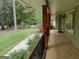 Long covered front porch featuring stone and wood supports with a view to the front yard at 205 Aberdeen Dr, Peachtree City, GA 30269