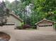 View of the 2-car and 1-car detached garages, both painted with white garage doors at 205 Aberdeen Dr, Peachtree City, GA 30269