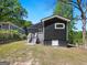 Backyard view of a modern home with dark siding, green lawn and a set of stairs at 1599 Ezra Church Nw Dr, Atlanta, GA 30314