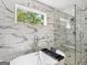 Bright bathroom featuring a modern bathtub, seamless glass shower, and marble-patterned tile at 1599 Ezra Church Nw Dr, Atlanta, GA 30314