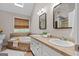 A well-lit bathroom features a double sink vanity and a soaking tub with a tiled surround at 212 Birkhill, Peachtree City, GA 30269