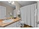 A well-lit bathroom features a single sink vanity, a toilet, and a shower with a curtain at 212 Birkhill, Peachtree City, GA 30269