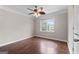 A bedroom with hardwood floors and a ceiling fan, showing natural light from a window at 212 Birkhill, Peachtree City, GA 30269