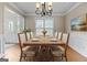 Dining room setup with table for 8, wainscoting, and a large window at 212 Birkhill, Peachtree City, GA 30269