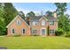 Well-maintained brick home featuring a symmetrical facade, grey shutters, and fresh landscaping at 212 Birkhill, Peachtree City, GA 30269