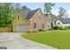 View of home with brick facade, attached garage, driveway, and well-maintained lawn at 212 Birkhill, Peachtree City, GA 30269