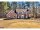 Charming two-story brick home boasts a symmetrical facade, complemented by lush greenery and a well-manicured front lawn at 212 Birkhill, Peachtree City, GA 30269