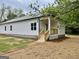 Charming home featuring white siding, a covered porch, and freshly installed landscaping at 304 N Dogwood Ave, Social Circle, GA 30025