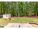 Spacious backyard presents mature trees, a tool shed, and a patio area, ideal for outdoor activities and gatherings at 122 Hilo Rd, Fayetteville, GA 30215