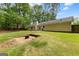 Expansive backyard displaying lush greenery, a fire pit, and the home's exterior, perfect for outdoor living at 122 Hilo Rd, Fayetteville, GA 30215