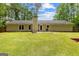 Large backyard exhibits a well-maintained lawn and the house, a beautiful space for recreation and relaxation at 122 Hilo Rd, Fayetteville, GA 30215