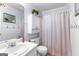 Neat bathroom equipped with a vanity sink, toilet, shower with curtain, and wall-mounted storage, promoting functionality at 122 Hilo Rd, Fayetteville, GA 30215