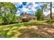 Expansive backyard featuring a deck, lush lawn, and mature trees, perfect for outdoor activities and relaxation at 120 Lyndhurst Way, Sharpsburg, GA 30277