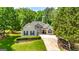 Charming one-story home with a stone-accented facade and meticulously landscaped front yard with a winding driveway at 120 Lyndhurst Way, Sharpsburg, GA 30277