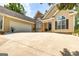 Close up of exterior featuring a two-car garage, manicured lawn, and flowerbeds by the door at 120 Lyndhurst Way, Sharpsburg, GA 30277