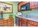 Compact kitchenette featuring dark wood cabinets, stainless steel appliances at 120 Lyndhurst Way, Sharpsburg, GA 30277