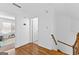 Hallway with hardwood flooring leading to a bedroom, featuring white walls and trim throughout at 195 Blackberry Run, Fayetteville, GA 30214