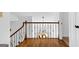 A staircase featuring decorative wrought iron railing, hardwood flooring, and a pendant light fixture at 195 Blackberry Run, Fayetteville, GA 30214