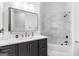 Bathroom with vanity featuring dark cabinets, marble countertops, gold fixtures, and tiled shower at 215 Sheridan Ln, Peachtree City, GA 30269
