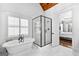 Bright bathroom featuring a soaking tub, glass shower, and views to main bedroom at 215 Sheridan Ln, Peachtree City, GA 30269