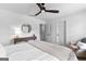 Comfortable bedroom with a fan, neutral carpet, plantation shutters, and a view to the bathroom at 215 Sheridan Ln, Peachtree City, GA 30269