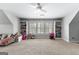 Bright bonus room with custom shelving, a cozy seating area, and a ceiling fan for comfortable Gathering living at 215 Sheridan Ln, Peachtree City, GA 30269