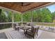 Inviting covered porch with wood ceiling and tranquil backyard view, furnished for comfortable outdoor living at 215 Sheridan Ln, Peachtree City, GA 30269