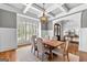 Elegant dining room featuring hardwood floors, wainscoting, and a coffered ceiling with stylish light fixture at 215 Sheridan Ln, Peachtree City, GA 30269