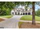 Beautiful two-story home with a three-car garage, lush landscaping, and a patterned driveway at 215 Sheridan Ln, Peachtree City, GA 30269