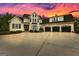 Spacious two-story home with a three-car garage and a wide concrete driveway at sunset at 215 Sheridan Ln, Peachtree City, GA 30269