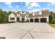 Front view of a spacious two-story home with a three-car garage and a wide concrete driveway at 215 Sheridan Ln, Peachtree City, GA 30269