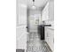 Well-lit laundry room with patterned tile floor, white cabinets, and modern washer and dryer at 215 Sheridan Ln, Peachtree City, GA 30269